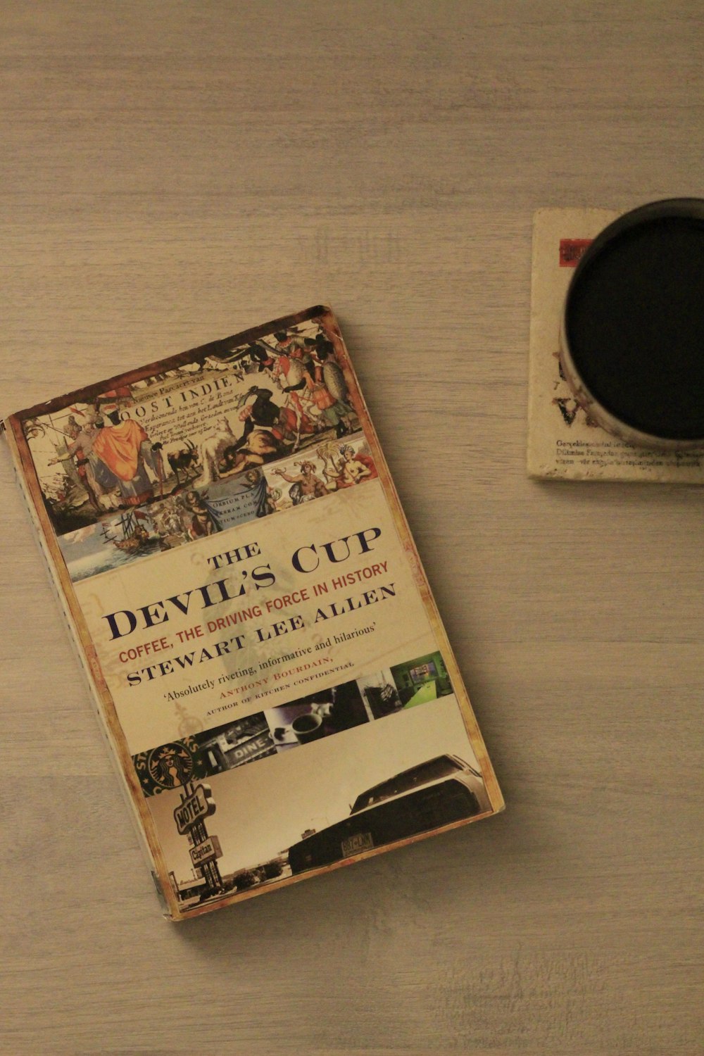 a book sitting on top of a table next to a cup of coffee