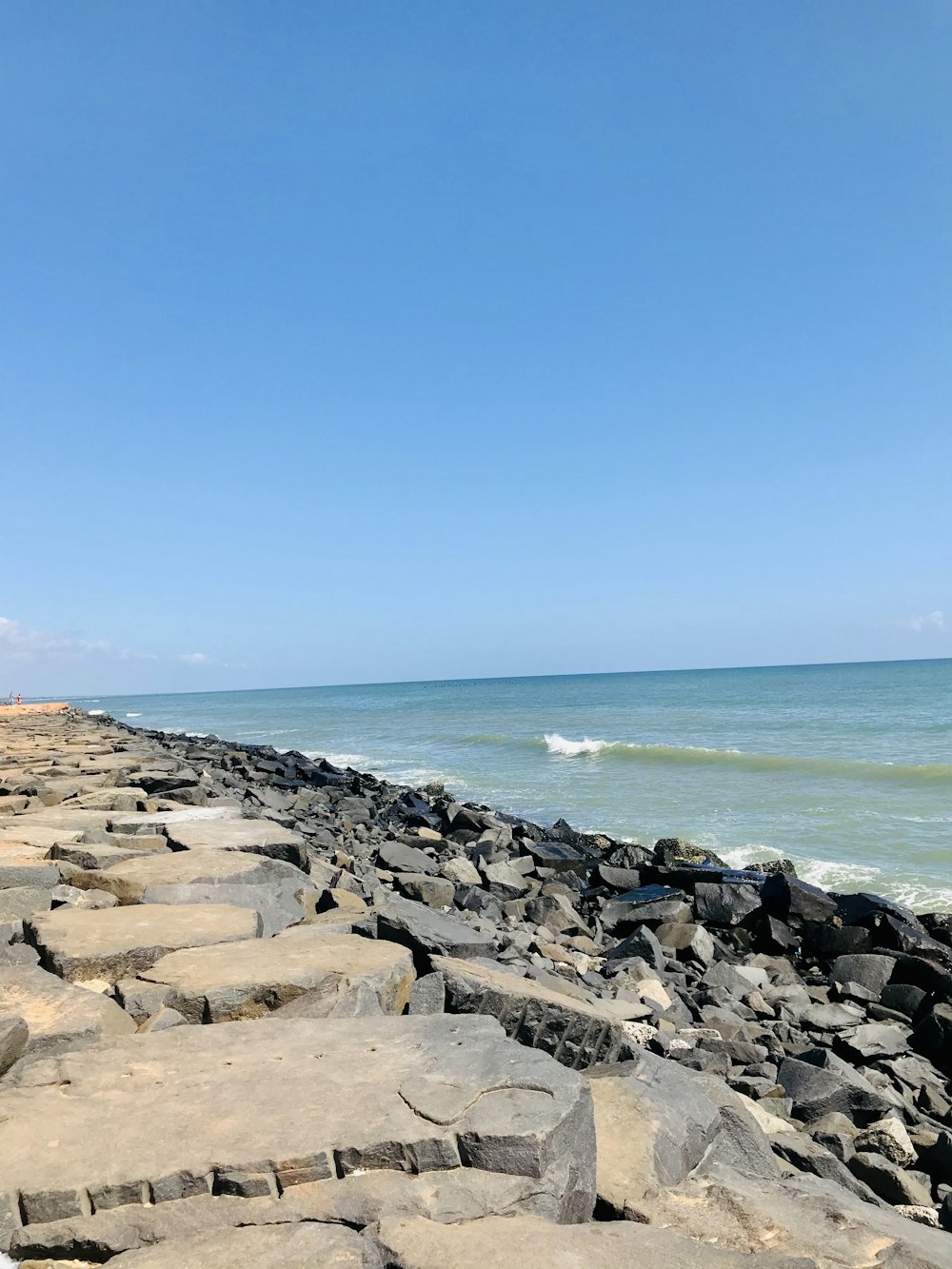 gray rocks near body of water during daytime