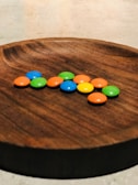 Colorful assortment of candies and sweets displayed in a rustic wooden tray.