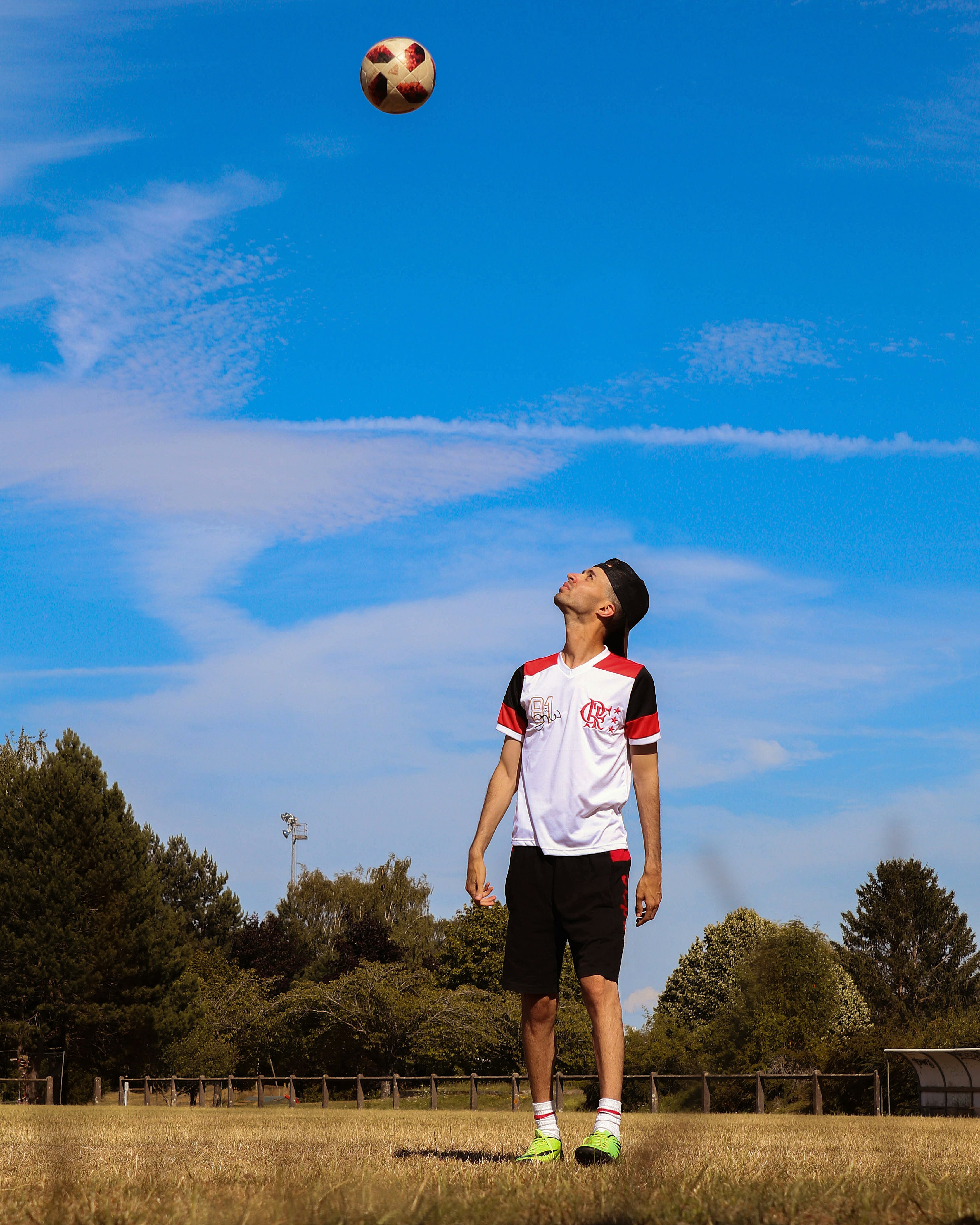 woman in white shirt standing on green grass field under blue sky during daytime