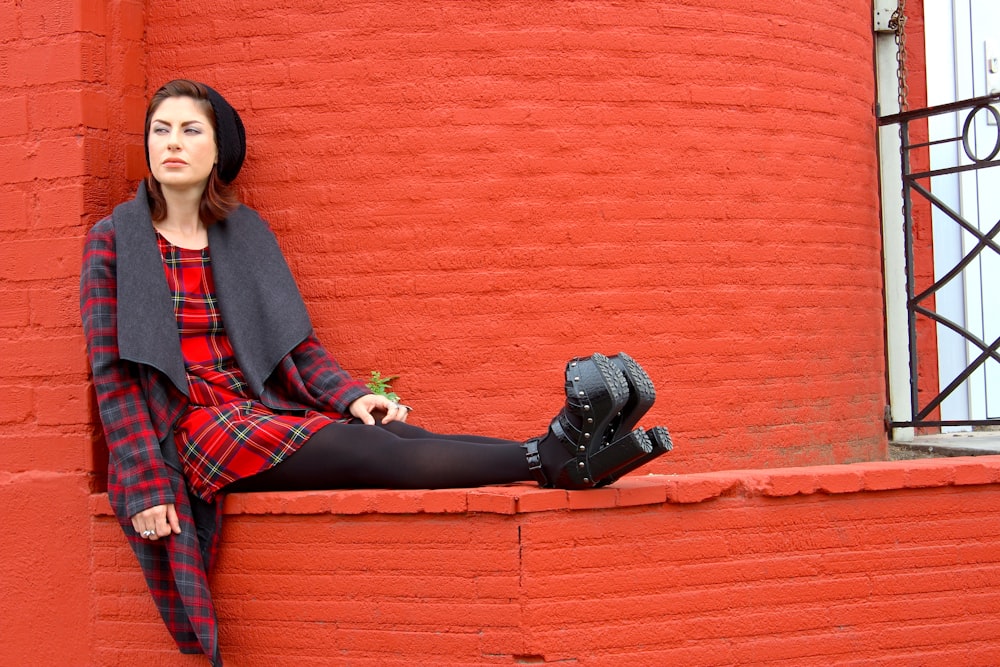 woman in red and black plaid long sleeve shirt holding black leather boots