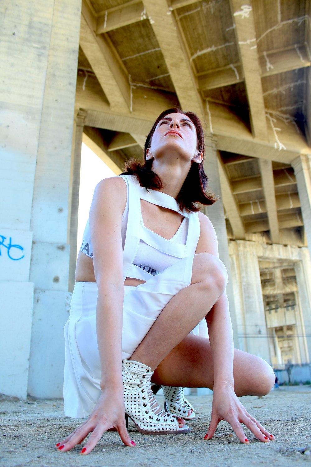 woman in white tank top and white shorts sitting on concrete bench