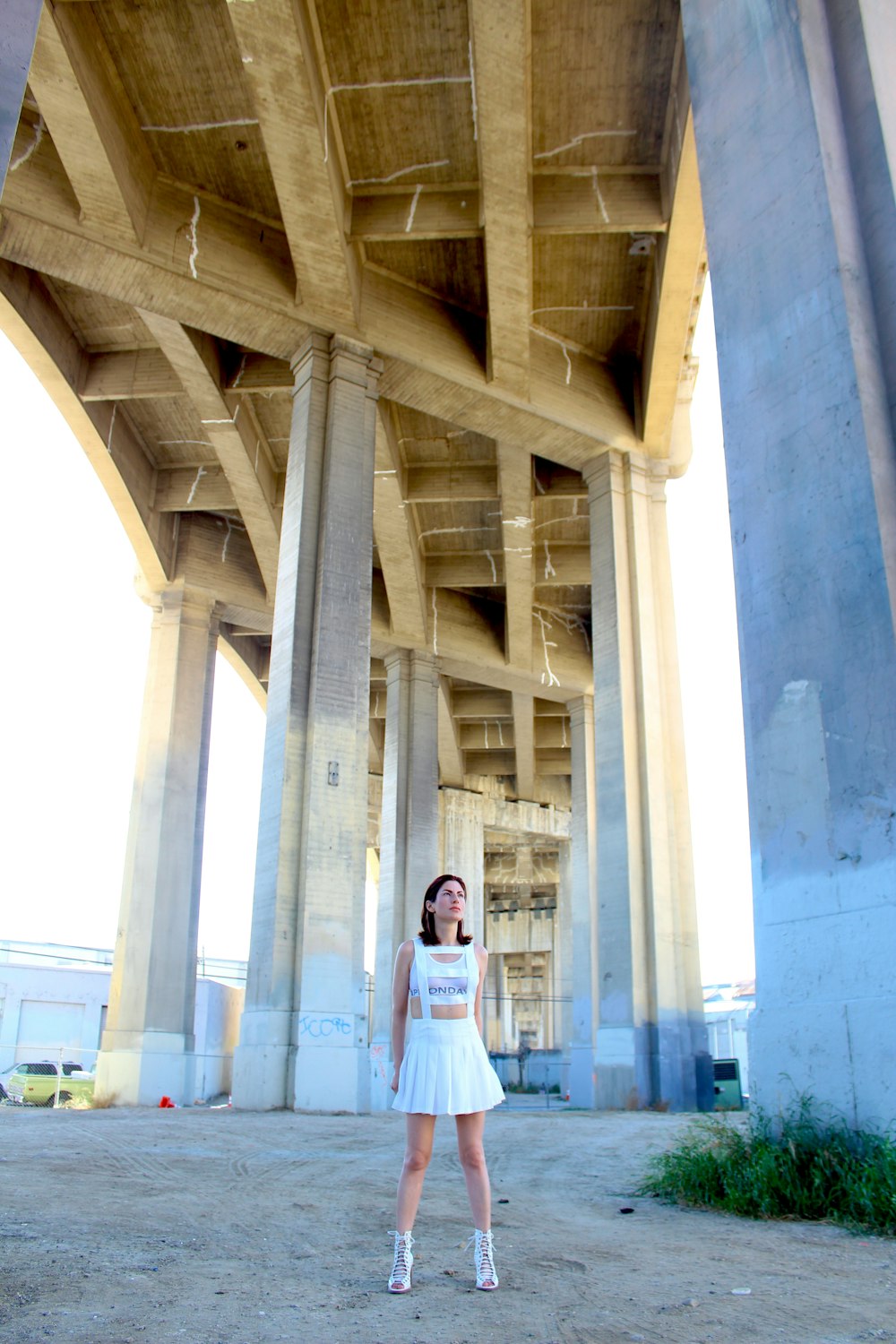 woman in white hijab standing under white concrete bridge during daytime