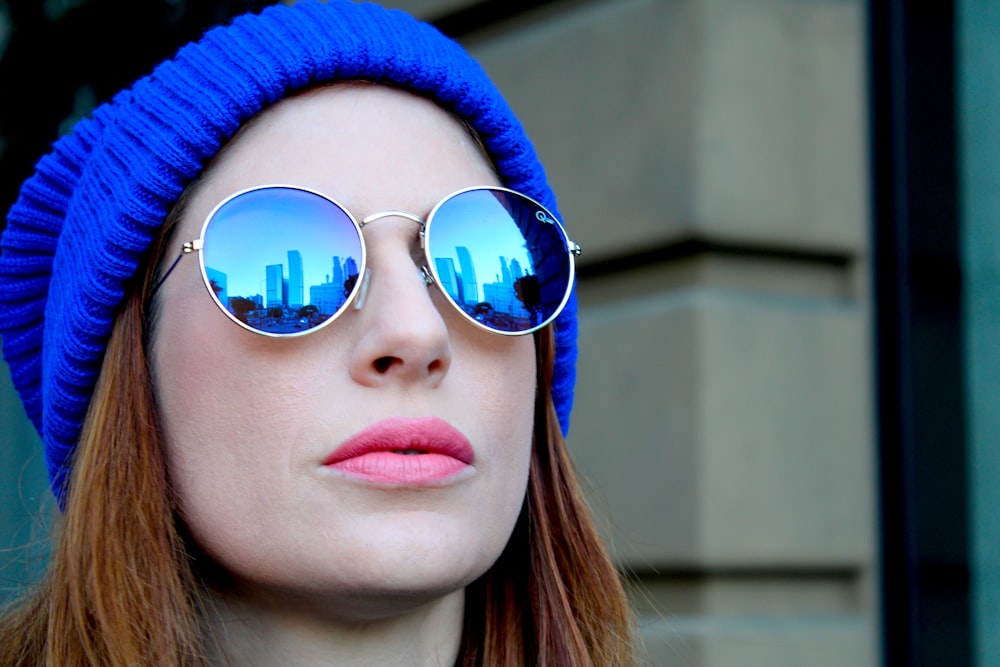 woman in blue knit cap wearing blue sunglasses