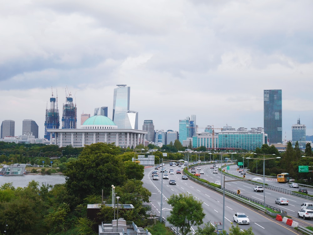 cars on road near city buildings during daytime