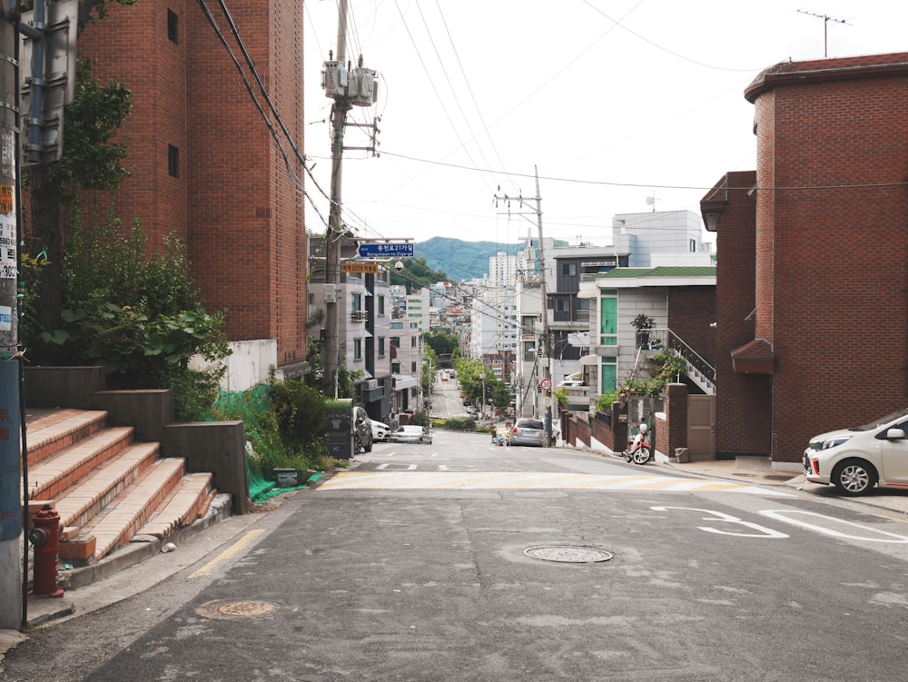 gray concrete road between brown concrete buildings during daytime