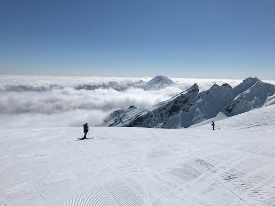 person in black jacket standing on snow covered mountain during daytime in Mount Ruapehu New Zealand