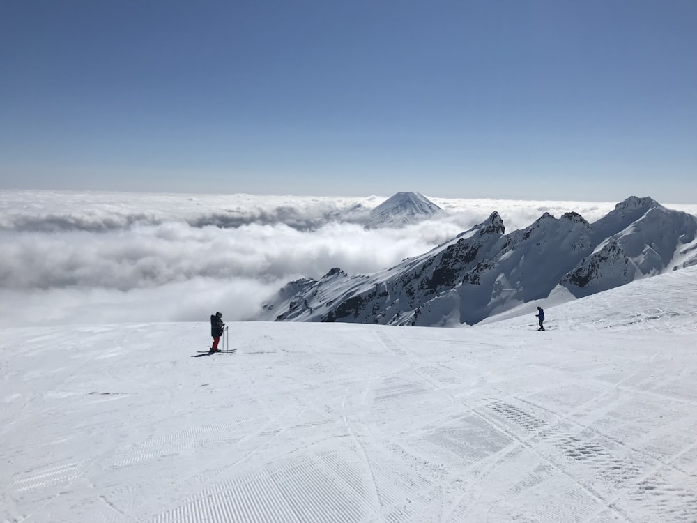 person in black jacket standing on snow covered mountain during daytime