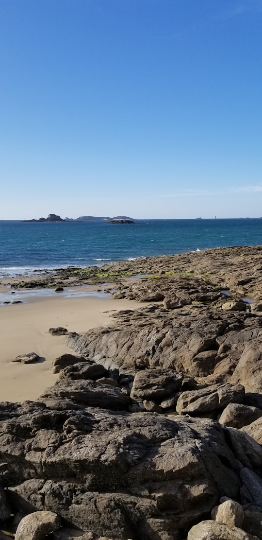 brown rocky shore under blue sky during daytime in Dinan France