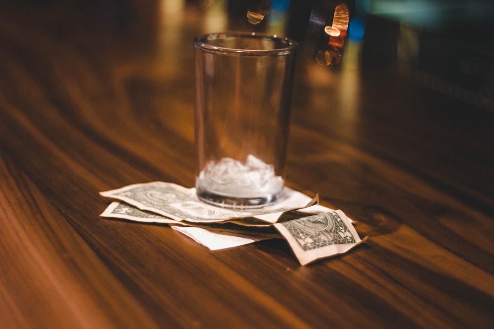 clear drinking glass on white tissue paper on brown wooden table