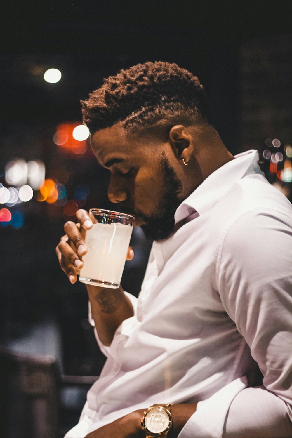 man in white dress shirt drinking beer