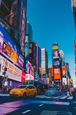 cars parked on street near high rise buildings during night time