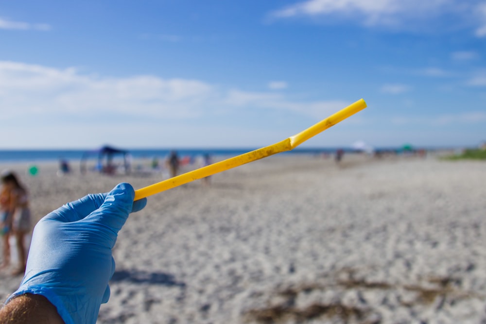 person holding yellow stick during daytime