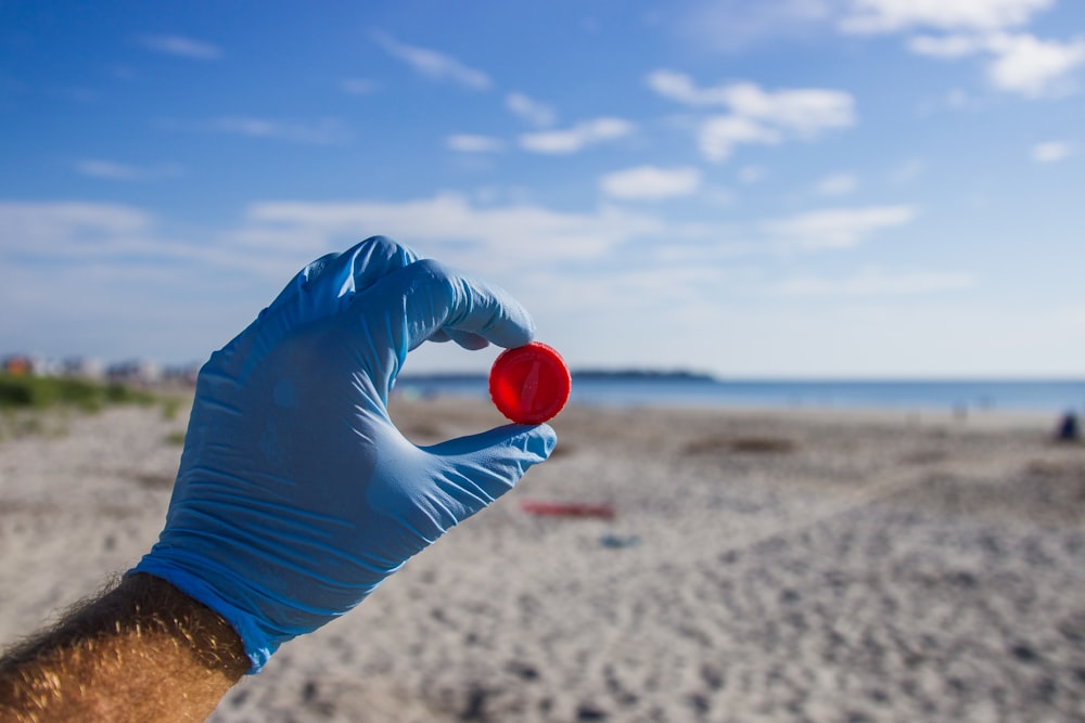 Frau in blauem Hemd und blauen Shorts liegt tagsüber auf Strandsand