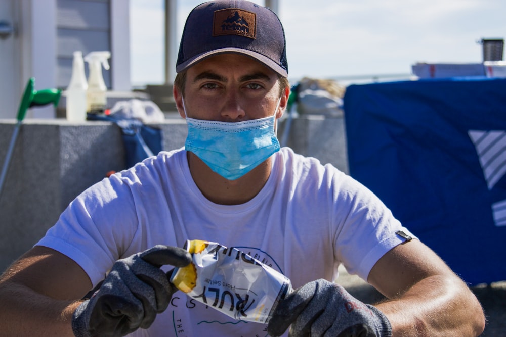 man in white crew neck t-shirt wearing blue and white mask