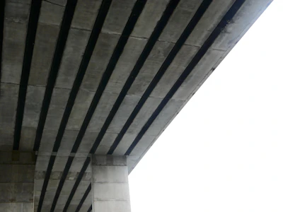 Side view of a sturdy railway bridge with freshly poured concrete sections curing.