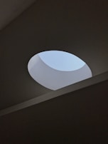 Circular skylight diffuser stretch ceiling adding natural light effect in a luxury home.