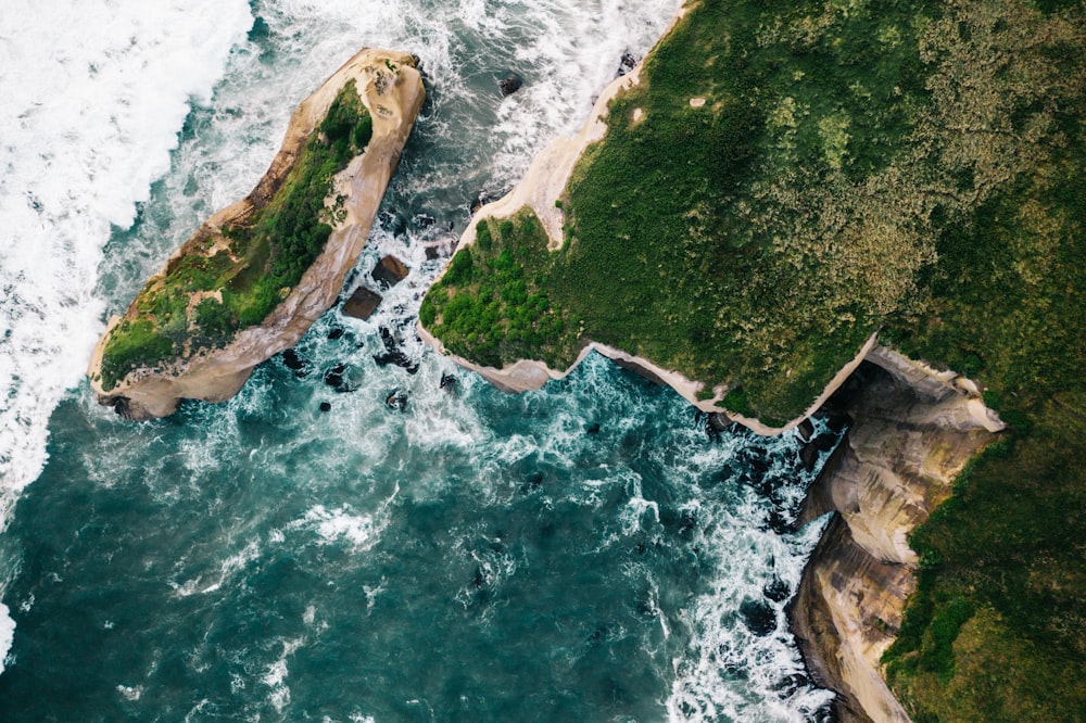 brown rock formation beside body of water during daytime