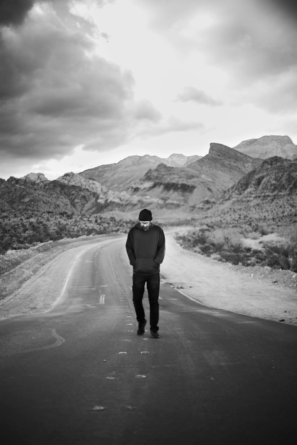 man in black jacket walking on road