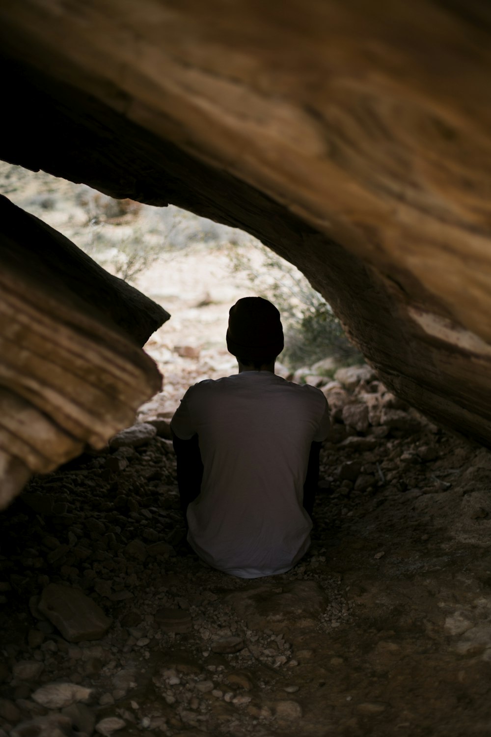homme en chemise blanche assis à l’intérieur de la grotte