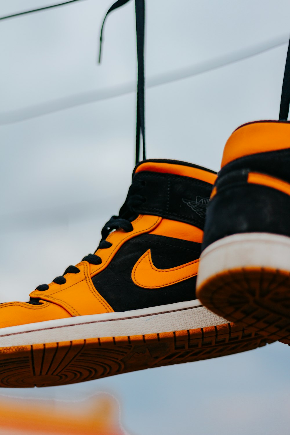 person wearing orange and black nike high top sneakers