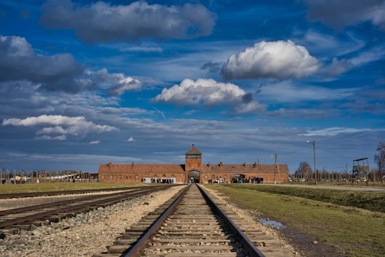 brown concrete building under blue sky during daytime in Camp Birkenau Historical Gate Poland