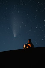 man in black shirt sitting on black chair under starry night