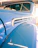 Close-up of a vintage car's polished chrome details shining under indoor lighting.