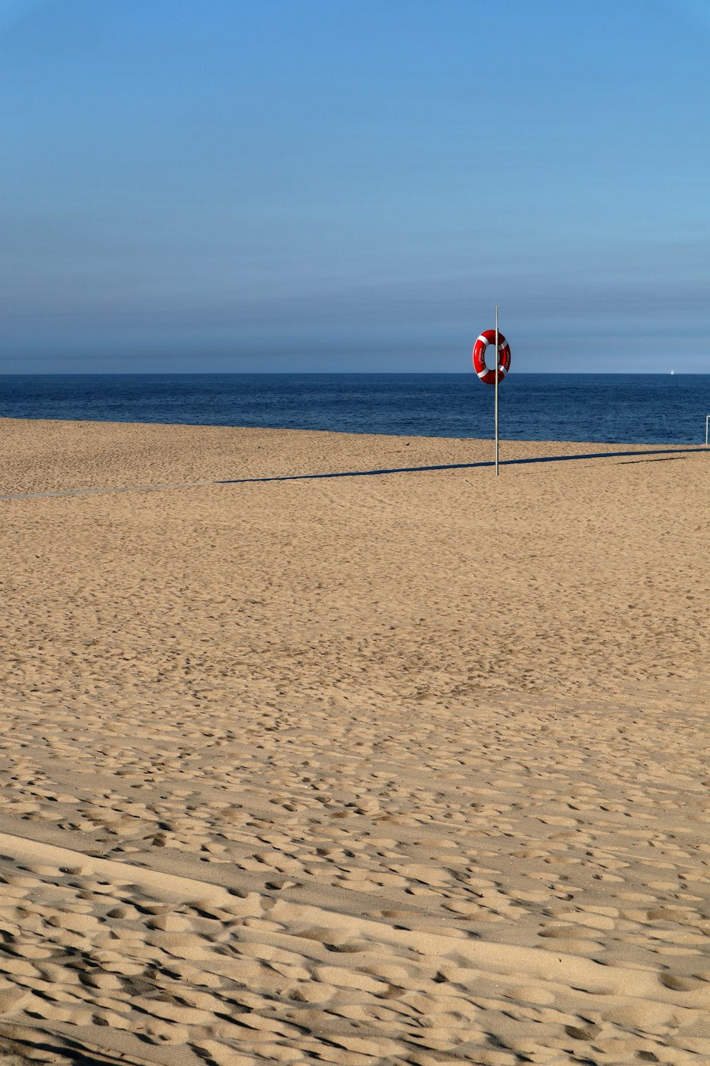 person in red shirt standing on brown sand during daytime