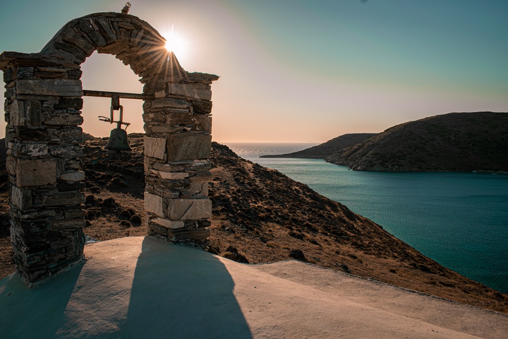 brown concrete arch near body of water during daytime