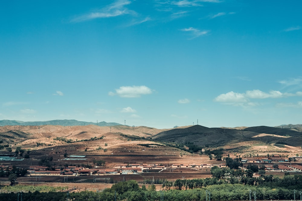 green trees and brown mountains under blue sky during daytime