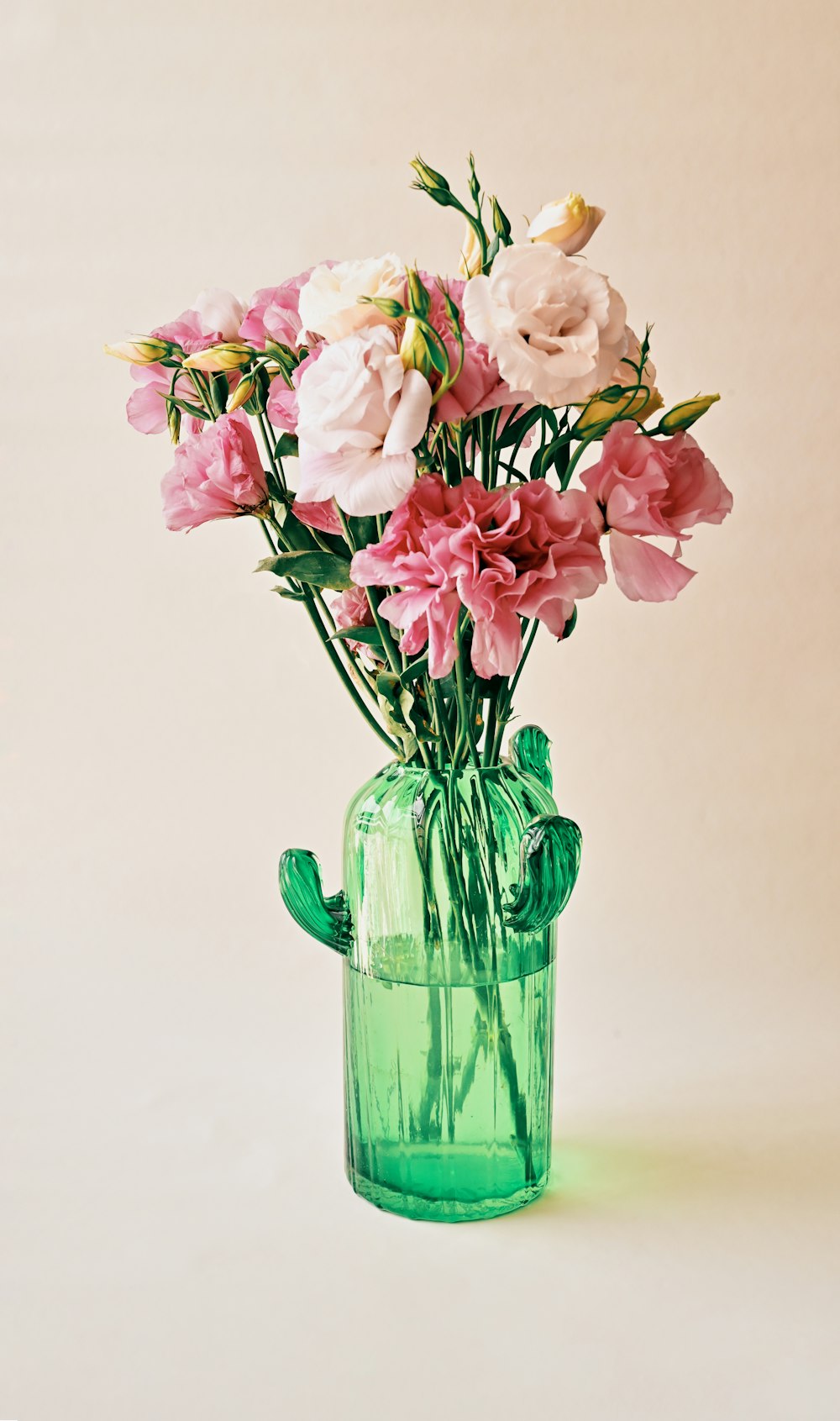 녹색 유리 꽃병에 분홍색과 흰색 꽃