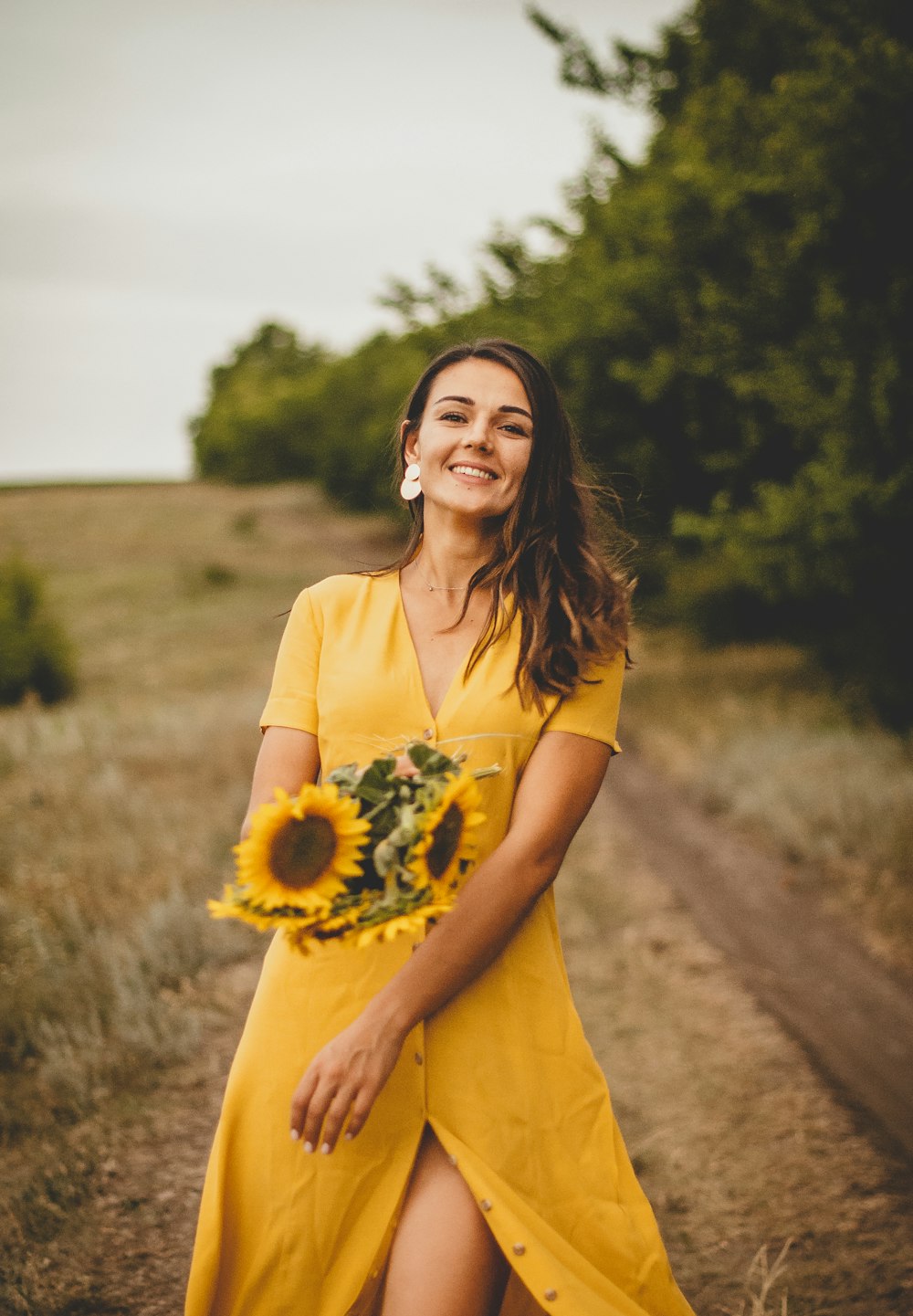 woman in yellow dress holding sunflower