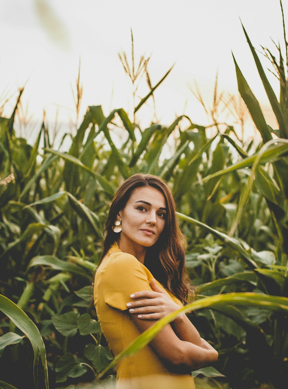 woman in yellow long sleeve shirt standing on green grass field during daytime