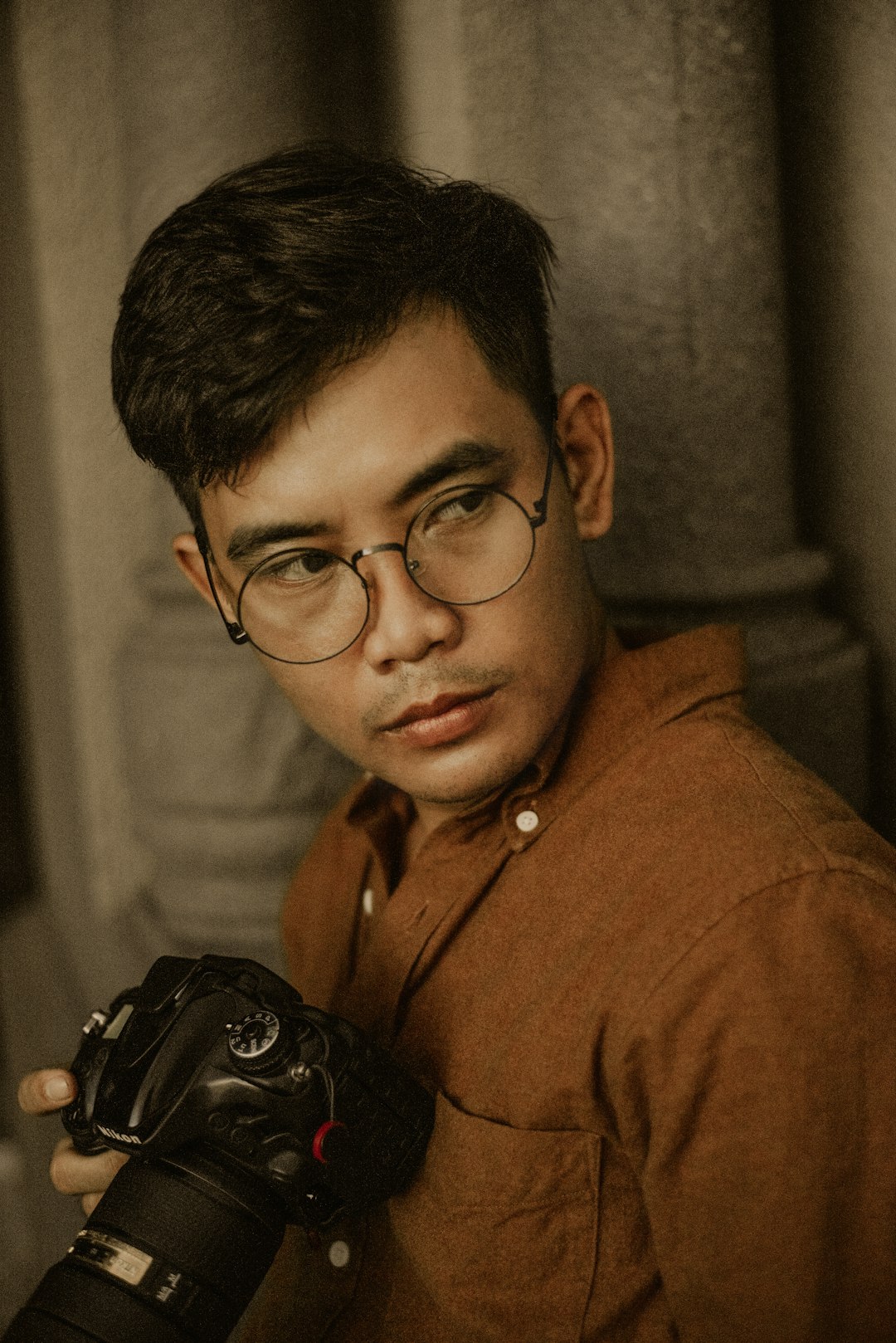 man in brown button up shirt wearing black framed eyeglasses