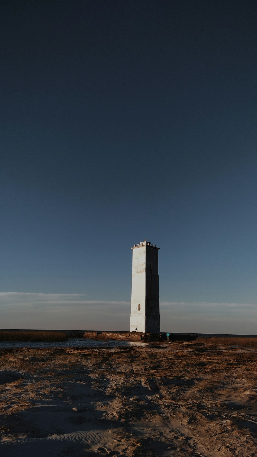 white and black lighthouse under blue sky during daytime