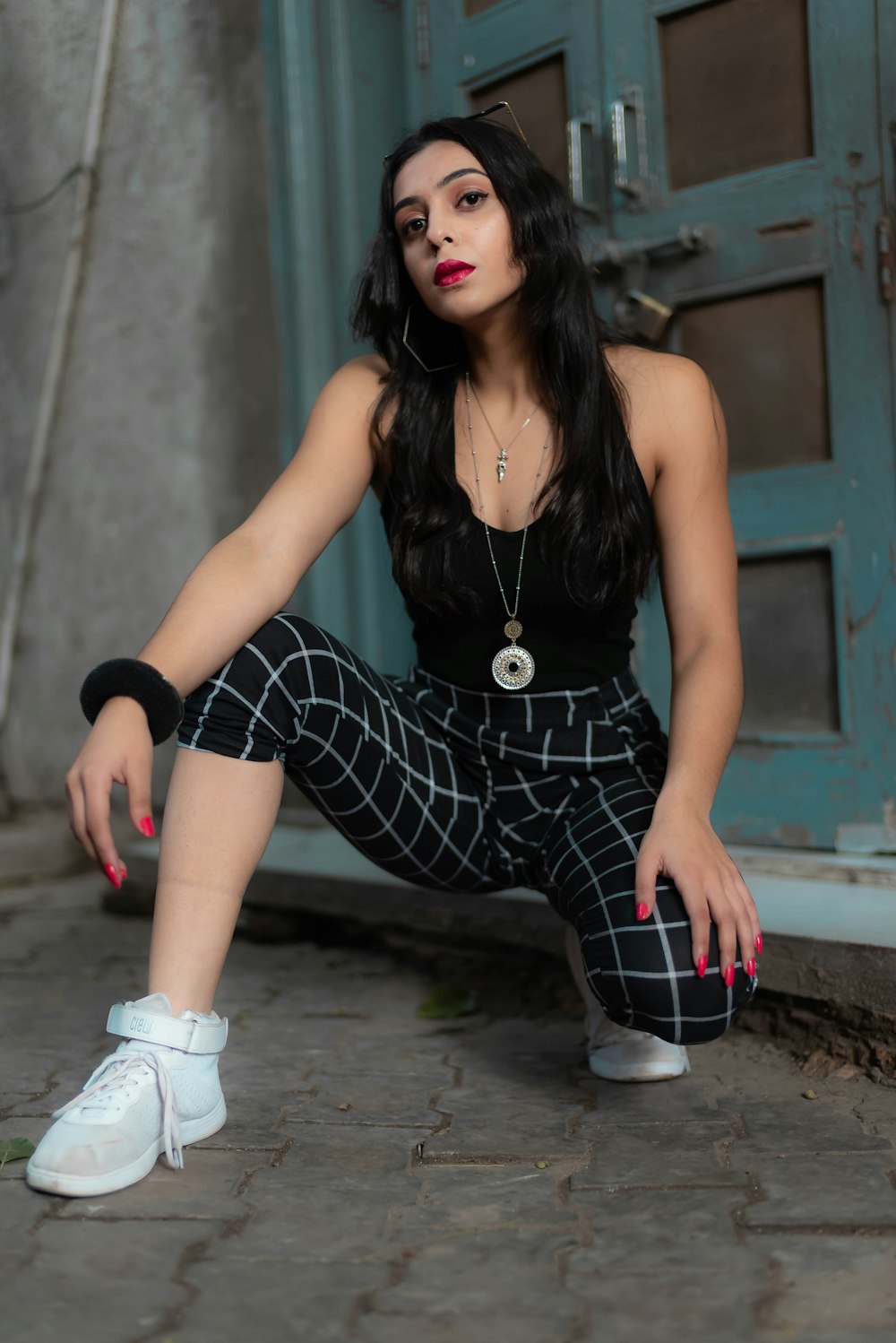 woman in black and white stripe dress sitting on concrete floor