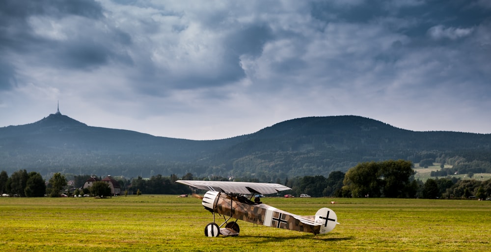 white and black plane on green grass field during daytime