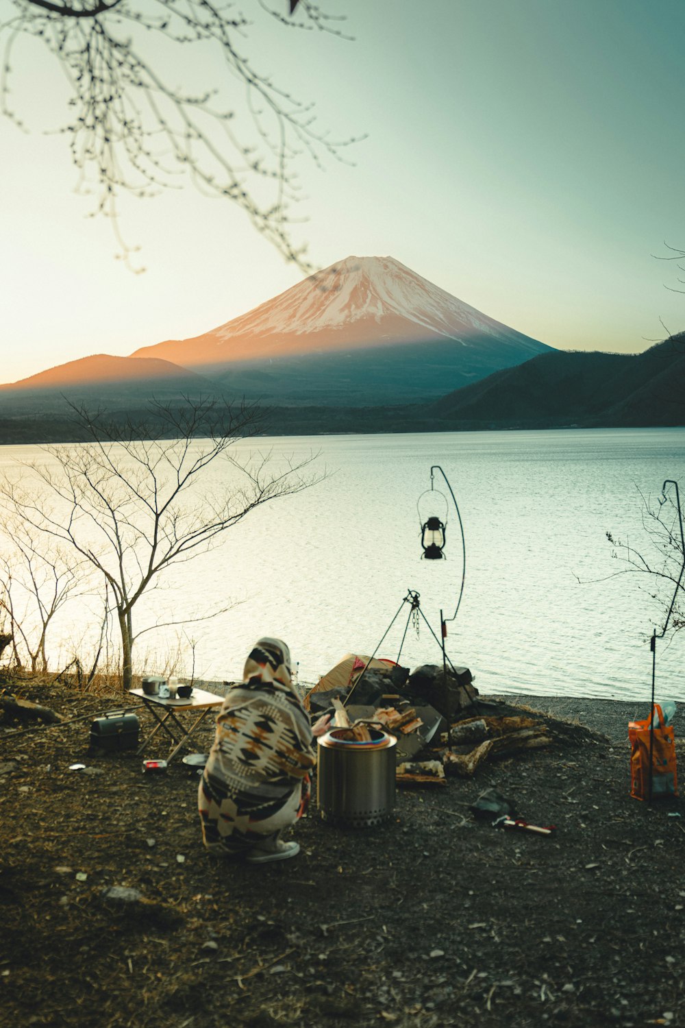 people sitting on ground near lake during daytime