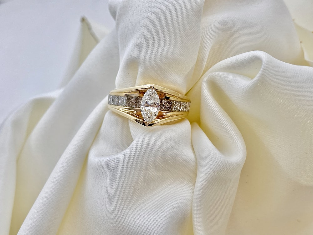 gold ring on white textile