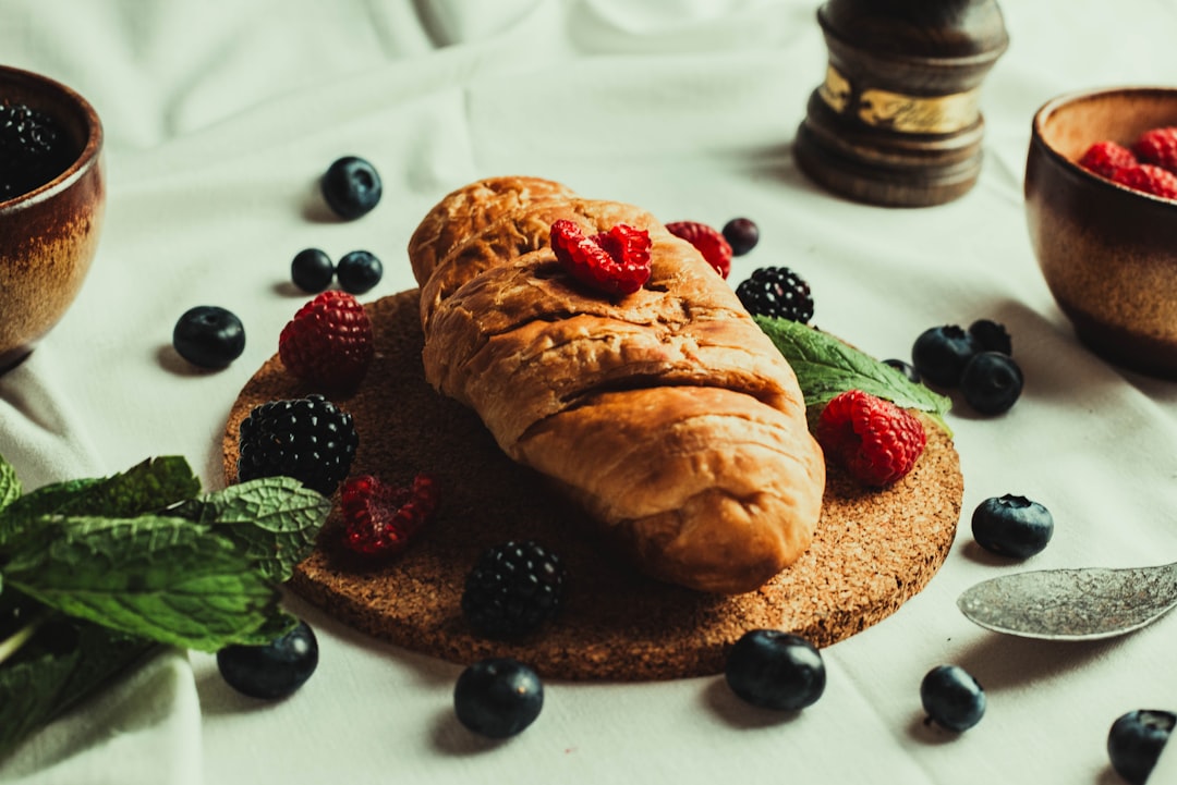 bread with raspberry and blueberry on white ceramic plate