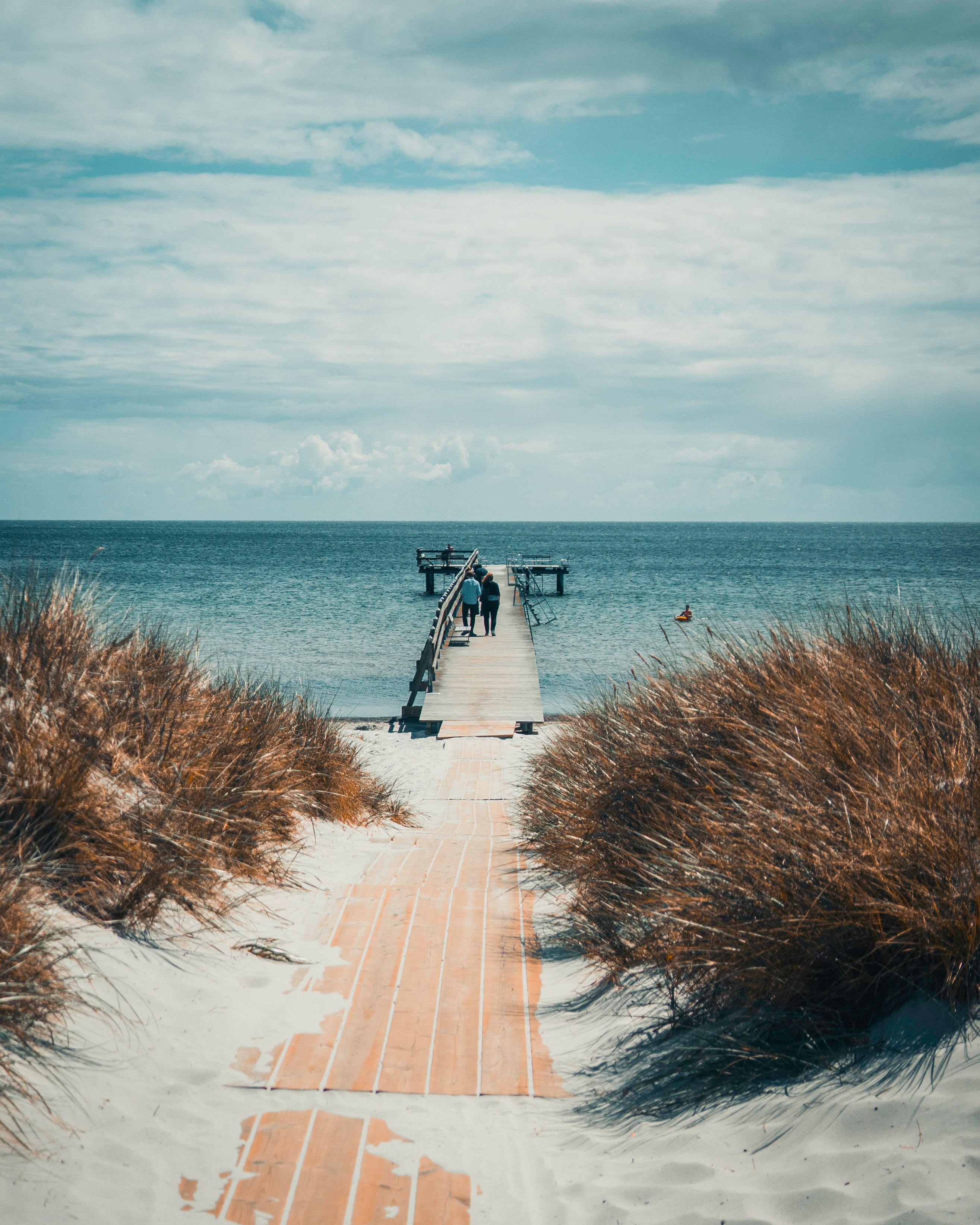 white and black wooden house near body of water during daytime