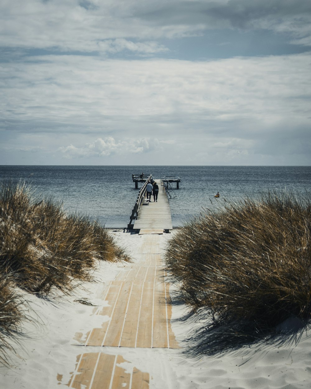 white and black wooden house near body of water during daytime