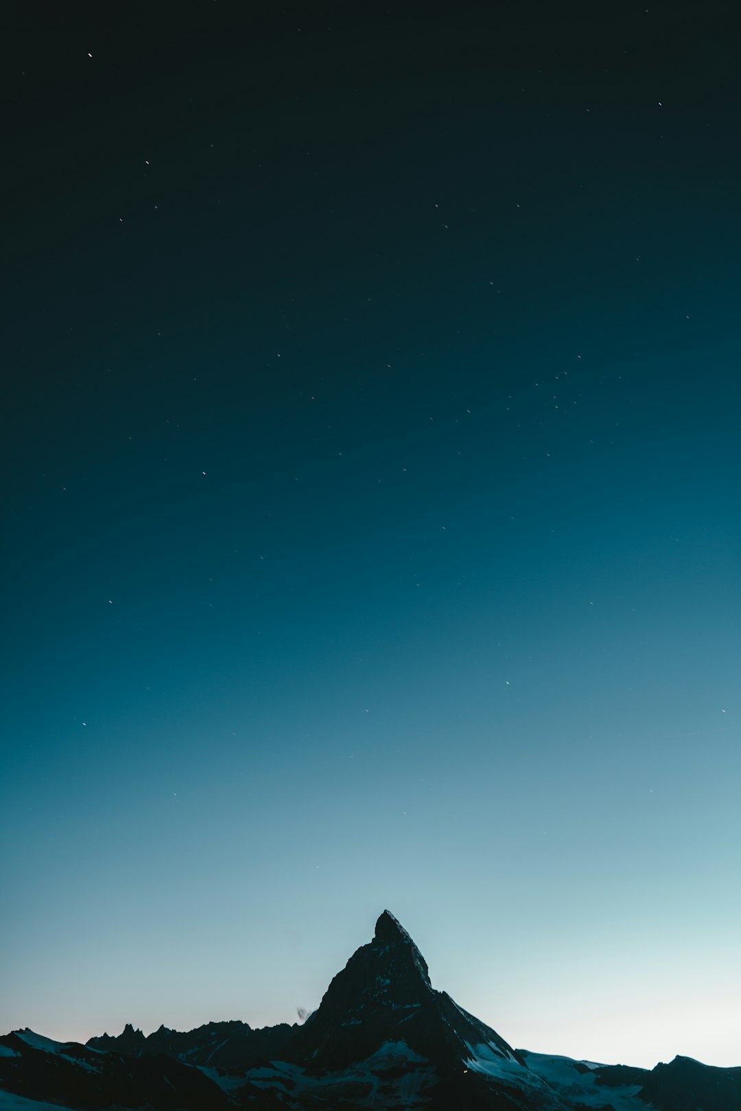 silhouette of mountain under blue sky during night time