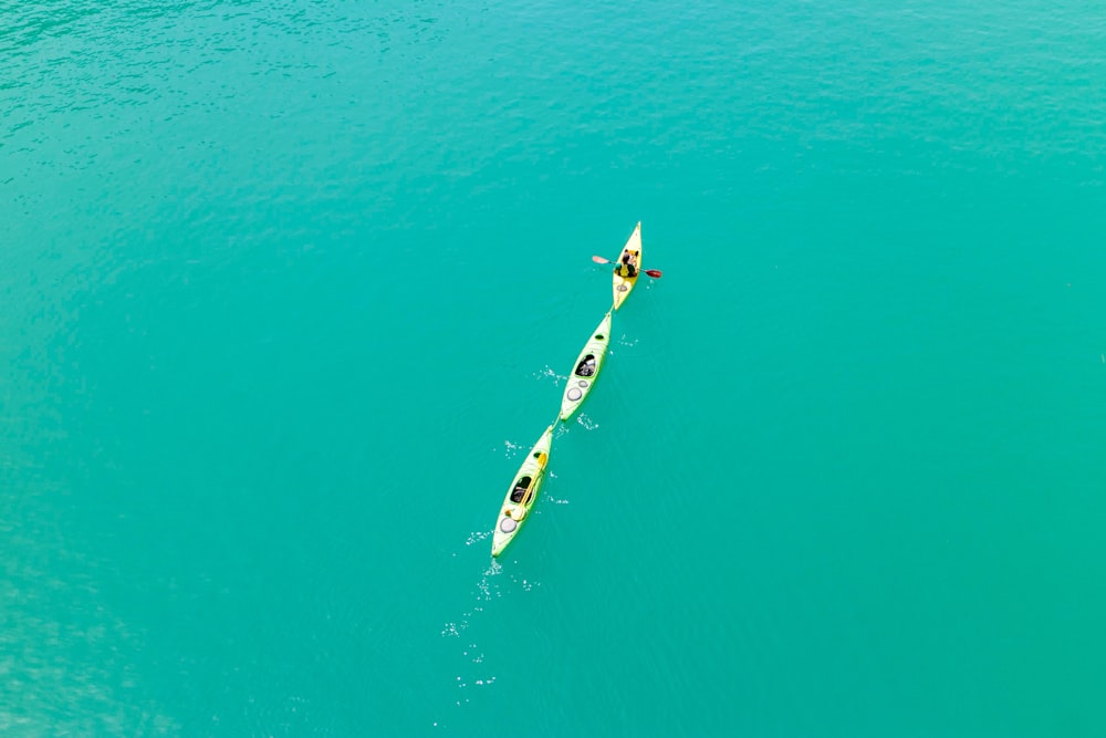 Persona en tabla de surf blanca y azul en medio del mar durante el día