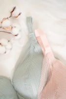 Flat lay of menstrual underwear alongside natural elements like flowers and soft textiles.
