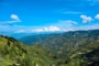 green mountains under blue sky and white clouds during daytime