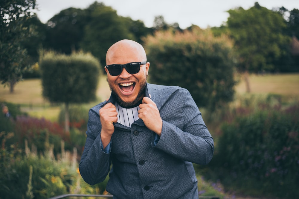 man in gray suit jacket wearing black sunglasses