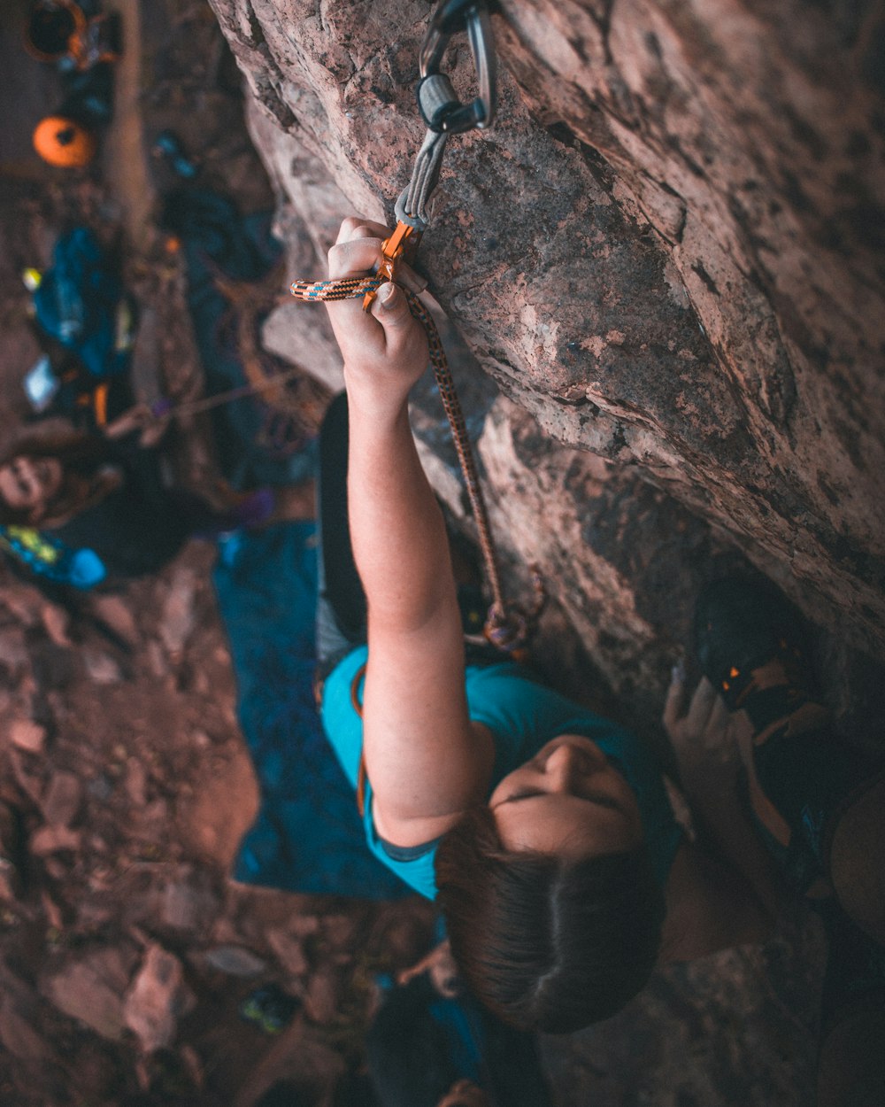 woman in black leather boots climbing on brown rock