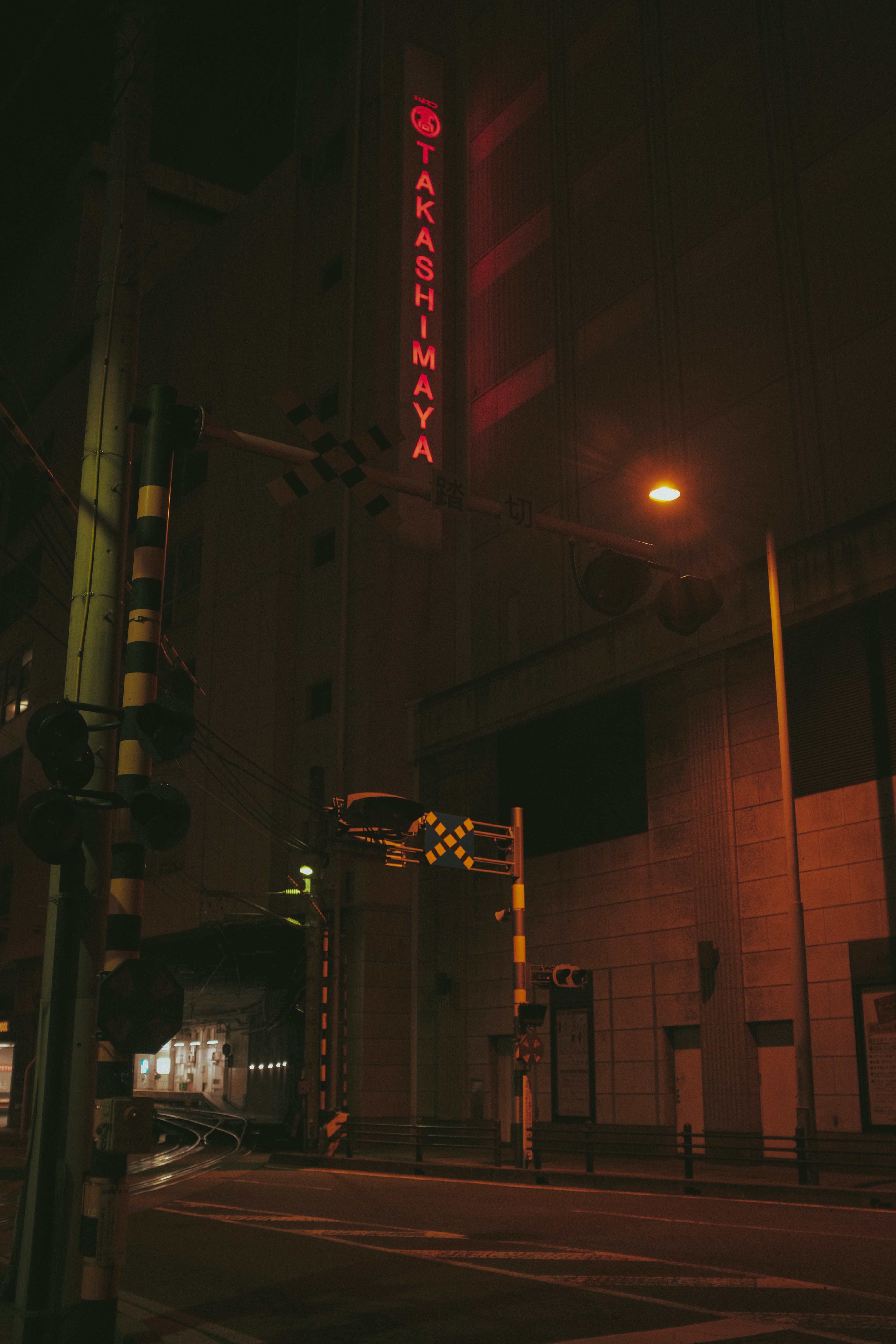 a city street at night with a neon sign